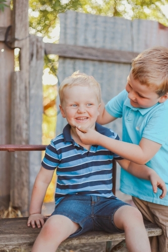 Big brother being silly making little brother smile - Australian Stock Image