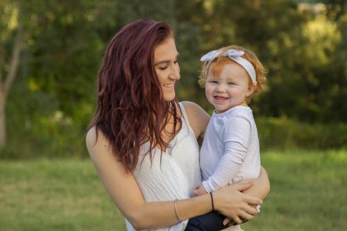 Big sister holding little sister outside - Australian Stock Image
