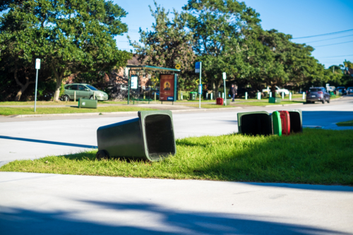 bins scattered on the sidewalk on a windy day - Australian Stock Image