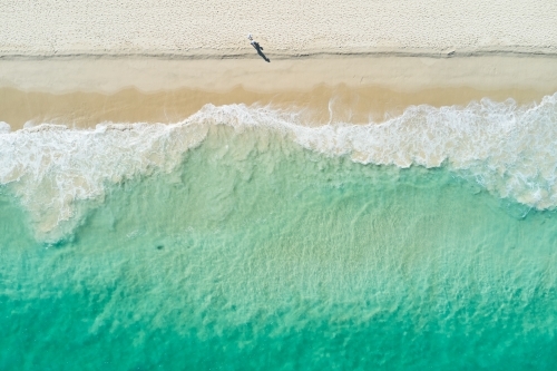 Bird's Eye View of Couple Walking Along A Sandy Beach - Australian Stock Image