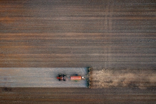 Birds eye view of tractor seeding a dusty paddock - Australian Stock Image