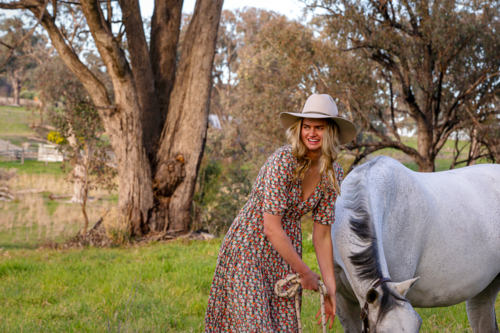 Blond cowgirl with white dressage horse - Australian Stock Image