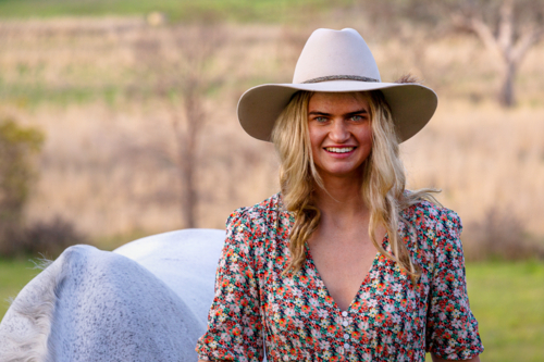 Blond cowgirl with white dressage horse - Australian Stock Image
