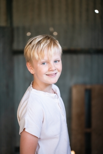 blonde pre-teen boy with relaxed pose in rustic county setting - Australian Stock Image