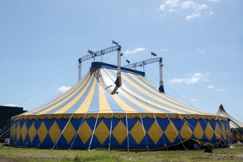 Blue and yellow circus tent with australian flags on top. - Australian Stock Image