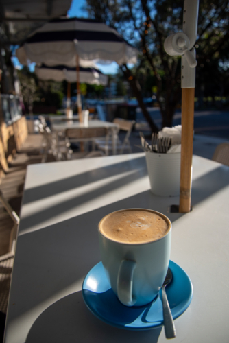 Blue coffee cup on a table early in the morning - Australian Stock Image