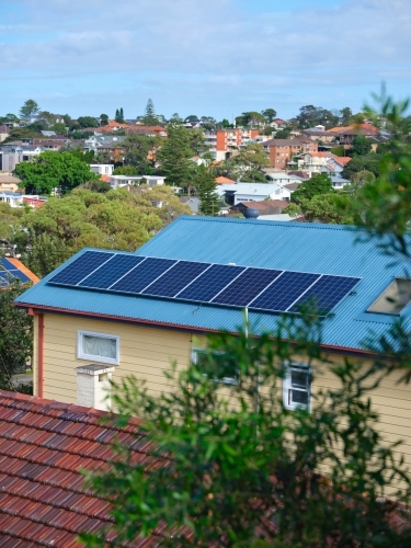 Blue coloured roof with solar panels and a view with houses - Australian Stock Image