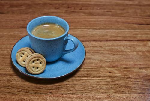 Blue cup with black coffee and two biscuits - Australian Stock Image