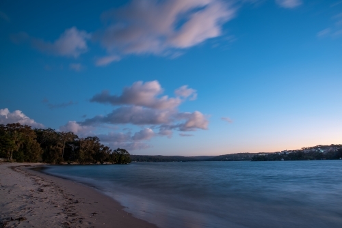 Blue hour photo of urban beach with clouds in the sky