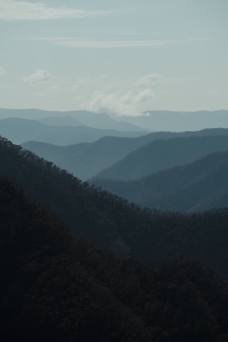 Blue mountain layers through the valley at Kanangra Walls Lookout on a sunny day - Australian Stock Image