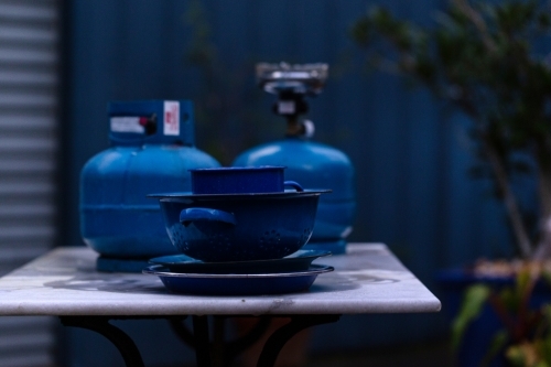 Blue objects on table in front of blue fence