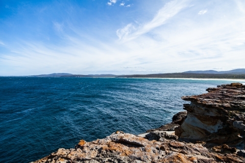 Blue ocean water and rocks of an island of the coast - Australian Stock Image
