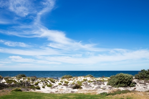 blue sky over calm water and white sand - Australian Stock Image