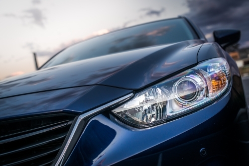 Blue station wagon on suburban street with luxury homes - Australian Stock Image