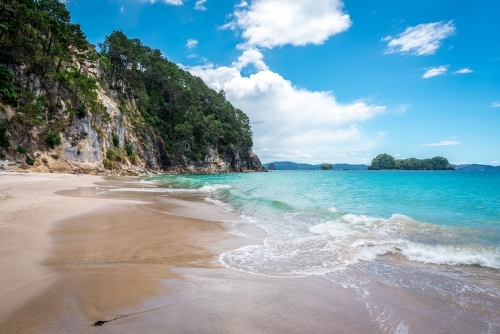 Blue water beach with high sand stone cliffs - Australian Stock Image