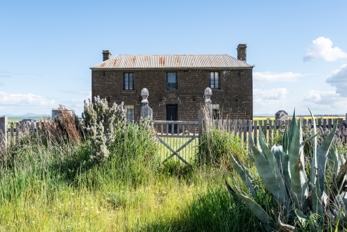 Bluestone free standing house and timber gate - Australian Stock Image