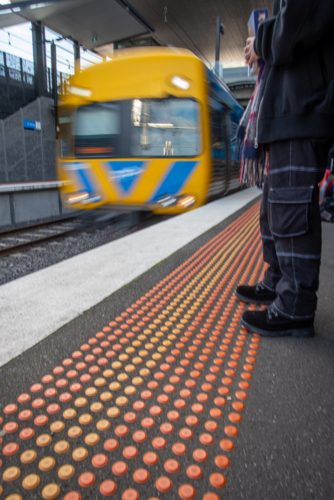 blurred Person standing on a train platform with a train arriving - Australian Stock Image