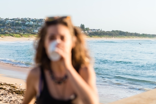 blurred woman, at beach in the morning with coffee