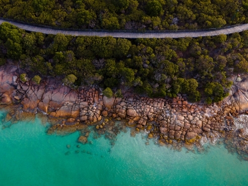 Boardwalk along coastline with clear turquoise water - Australian Stock Image