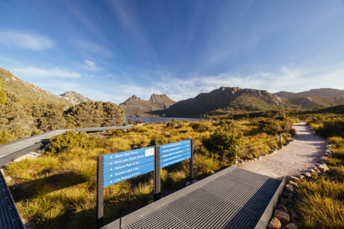 Boardwalk and paths around Dove Lake and Cradle Mountain on a warm autumn afternoon near sunset - Australian Stock Image
