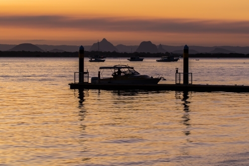 Boat and dock silhouetted in Pumicestone Passage - Australian Stock Image