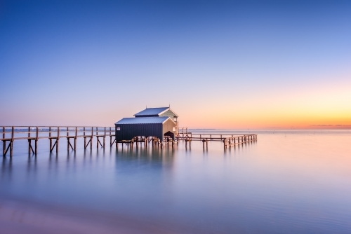 Boathouse on a beach at sunrise