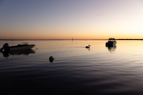 Boats floating on water at Sunrise in Venus Bay - Australian Stock Image