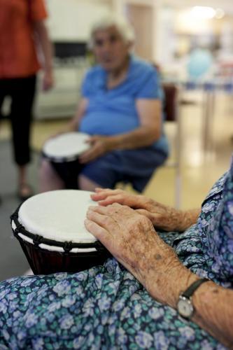 Bongo drumming activity session at retirement village - Australian Stock Image