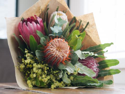 Bouquet of native flowers wrapped in brown paper on a table
