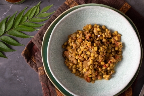 Bowl of Dahl Curry and ingredients around on dark background - Australian Stock Image