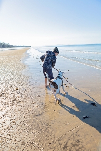 Boy and dog explore the remote coast of Queensland - Australian Stock Image