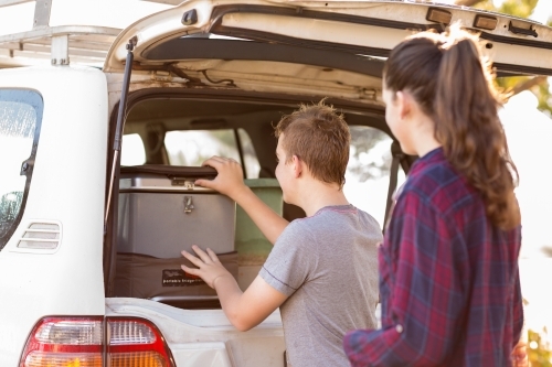 Boy and girl with camping gear in back of 4WD vehicle - Australian Stock Image