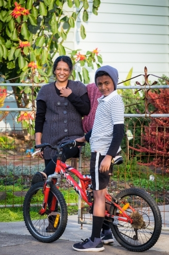 Boy and mum stand in front of their home - Australian Stock Image