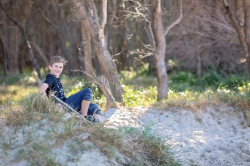 Boy having fun on the sand dunes on a remote beach in Queensand