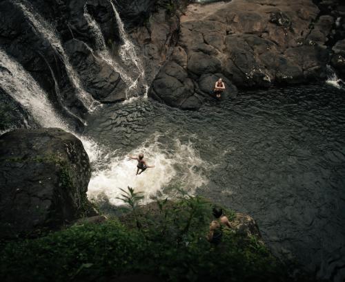 Boy jumping off a waterfall