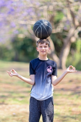 Boy playing outside with Jacaranda flowers - Australian Stock Image