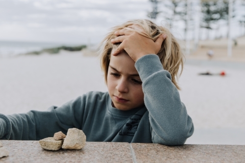 Boy playing with rocks - Australian Stock Image