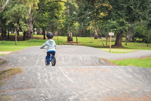 Boy riding his balance bike in Adelaide Parklands, South Australia - Australian Stock Image