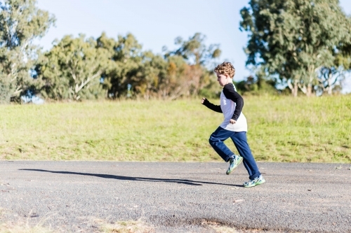 Boy running on path - Australian Stock Image