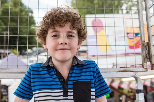 Boy sitting in ferris wheel cage at local show - Australian Stock Image