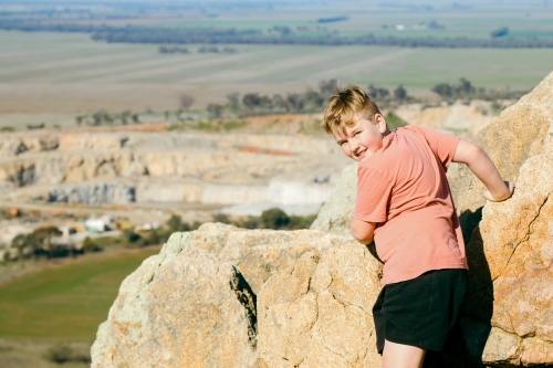 Boy standing at the summit of Pyramid Hill with view of quarry - Australian Stock Image