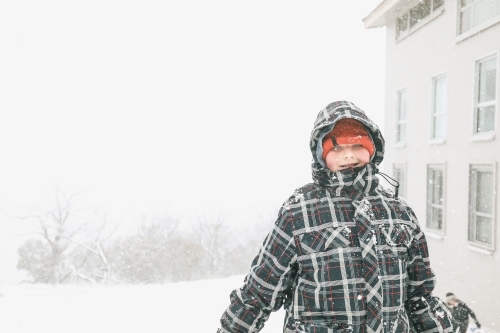 Boy standing in the snow on foggy day at Mount Buller - Australian Stock Image