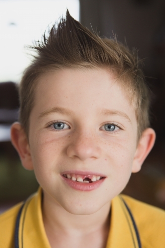 Boy with missing tooth smiling - Australian Stock Image