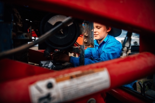 Boy working  behind farming equipment - Australian Stock Image