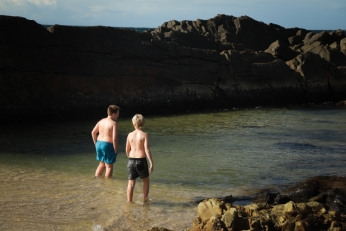 Boys swimming at The Tanks rocky tourist attraction at Forster, NSW Australia