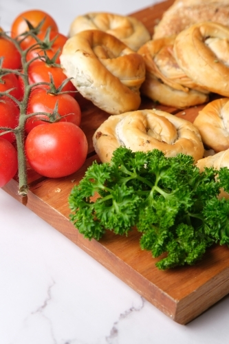 Bread knots and roll platter with herbs and cheese - Australian Stock Image