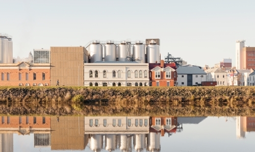 Brewery building on the side of the Tamar River, the building is reflected on the rivers surface - Australian Stock Image