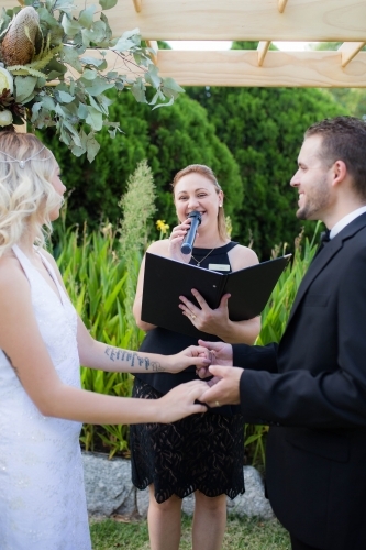 Bride and groom at wedding ceremony with celebrant - Australian Stock Image