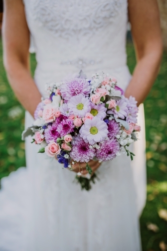Bride holding a bouquet of pink and purple flowers