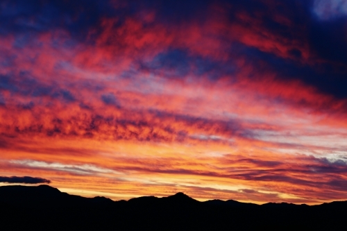 Brightly coloured sunset above mountains